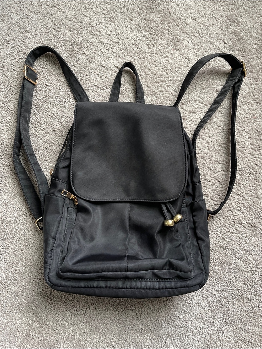 Nylon backpack with multiple compartments and adjustable straps.